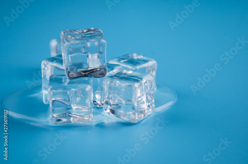 melting ice cubes on blue background