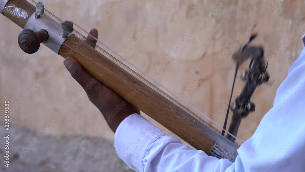 Indian musician play on traditional music instrument called Kamaycha ...