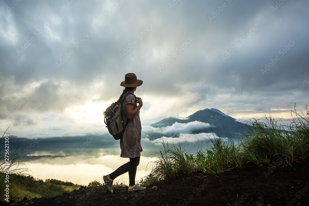 Woman enjoying sunrise from a top of mountain Batur, Bali, Indonesia. Woman enjoying sunrise from a top of mountain Batur, Bali, Indonesia.