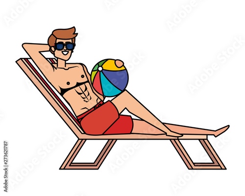young man relaxing in beach chair with balloon toy