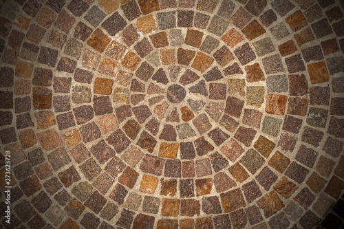 Circular texture of porphyry stone floor called Sanpietrini or Sampietrini, typical urban paving in Italy, Europe