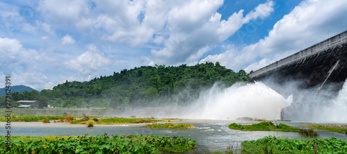 Amazing and beautiful water release at spillway or overflows at big dam with blue sky and cloud (Khun Dan Prakan Chon dam in Nakhon Nayok province Thailand)