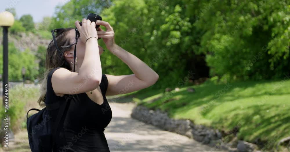Female photographer taking photos on walking path Female photographer taking photos on walking path