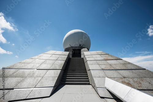 View of radar station against cloudy sky
