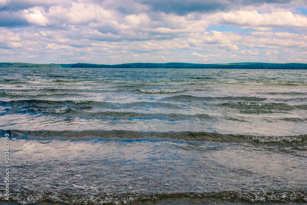 Small waves on the lake under the heavy cloudy sky. Nature landscape. Small waves on the lake under the heavy cloudy sky. Nature landscape.