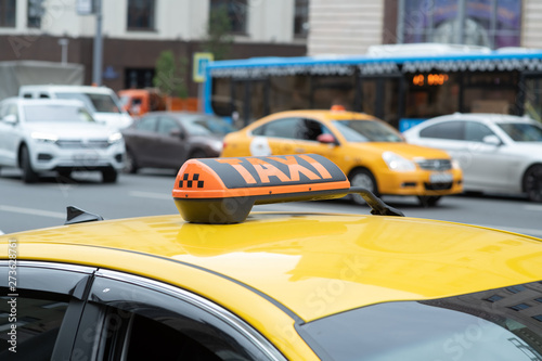 Yellow cab with taxi sign on the roof parked on the city street waiting for passengers to pick up.The taxi is parked on the street of the big city.Focus on the yellow lamp icon © spritnyuk