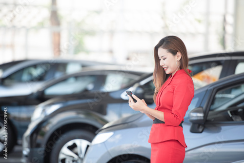 Asian women Shell sells traditional text messaging cars on smartphones in car showrooms.