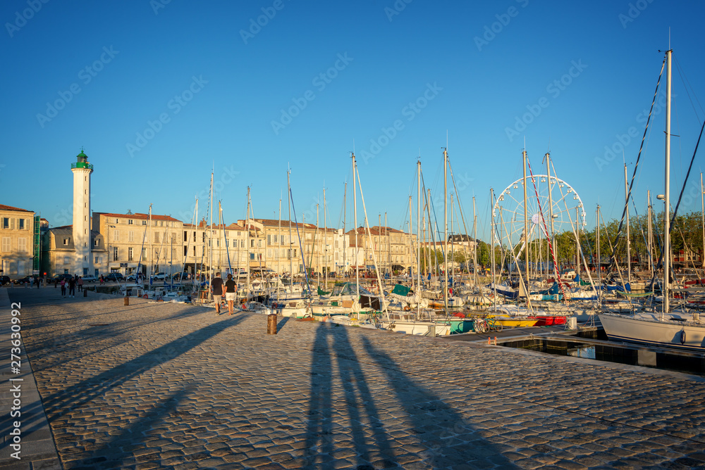 Sailboats in the old harbor of La Rochelle, France at sunset