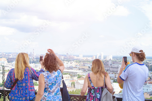A crowd of tourists takes pictures of a beautiful panoramic view of the city. © Юлия Усикова