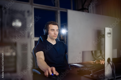Professional gamer in his expensive studio young man having live stream playing online video game. Cyber sportsman is streaming popular pc computer game for his followers    