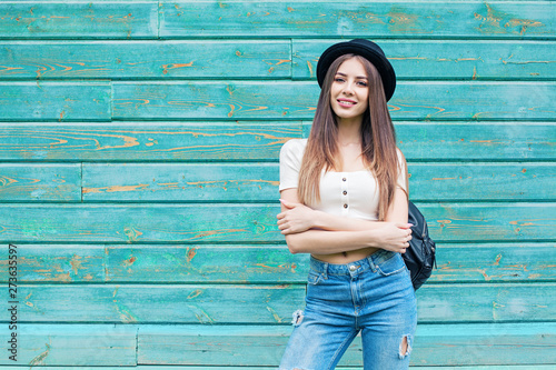 Happy young woman in blue denim on wooden background outdoors