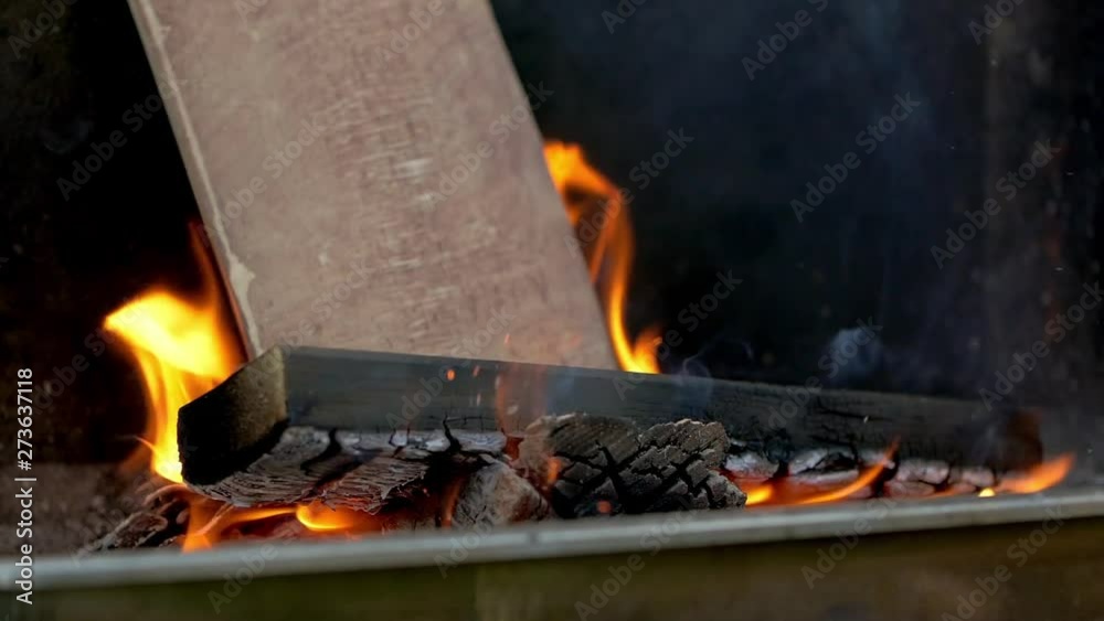 Burning Wood With Flames And Fire In Slow Motion, a stack of wood on a grill burns down in slow motion. filmed in 200fps.