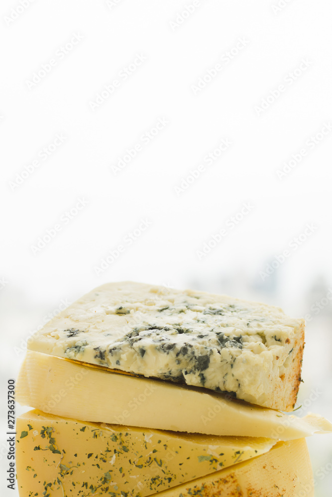 Stacked of triangular cheese slices against white background