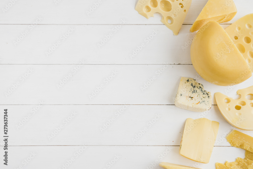 Gouda; maasdam and blue cheese on white wooden table - obrazy, fototapety, plakaty 