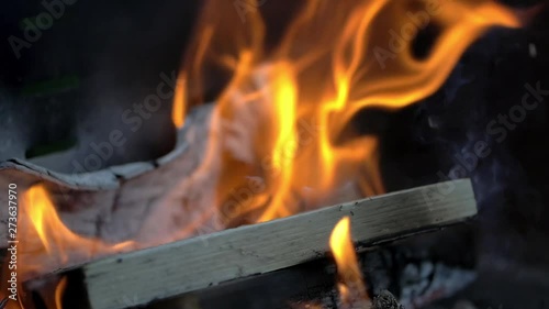 Burning Wood With Flames And Fire In Slow Motion, a stack of wood on a grill burns down in slow motion. filmed in 200fps.