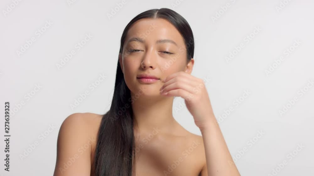 mixed race asian model in studio beauty shoot Fresh model with no makeup makeup watching to the camera amd touches her straight hair mixed race asian model in studio beauty shoot Fresh model with no makeup makeup watching to the camera amd touches her straight hair
