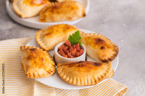 Homemade Spanish Empanadillas, small filling tuna pies served with tomato souse. Typical dish in Latin American and Spain cuisine.