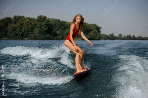 Woman in swimsuit on a board in sea
