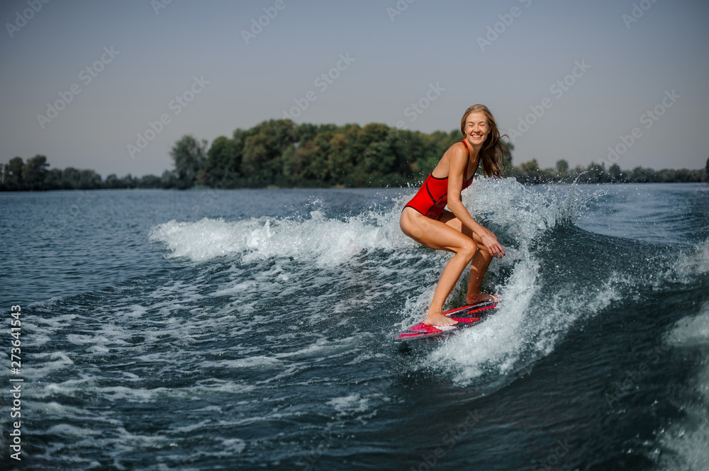 Girl in swimsuit on a board in sea