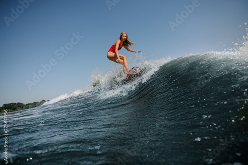 Woman with loose hair surfs in sea © fesenko