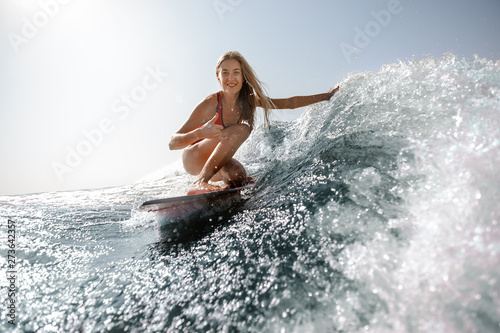 Close shot of woman in swimsuit surfing