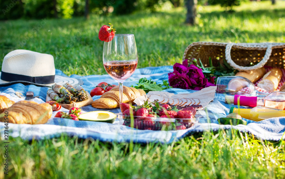 Summer picnic in the park on the grass. Wine, fruit and croissants Summer picnic in the park on the grass. Wine, fruit and croissants