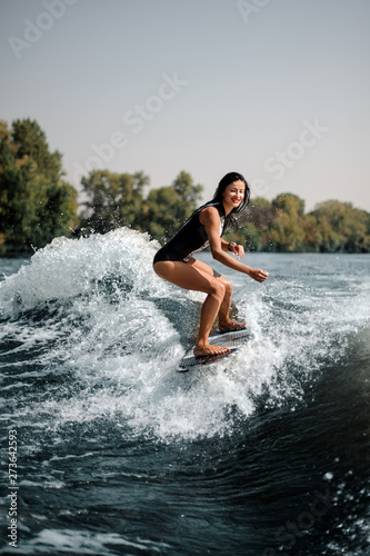 Smiling surfgirl on a surfboard near seashore