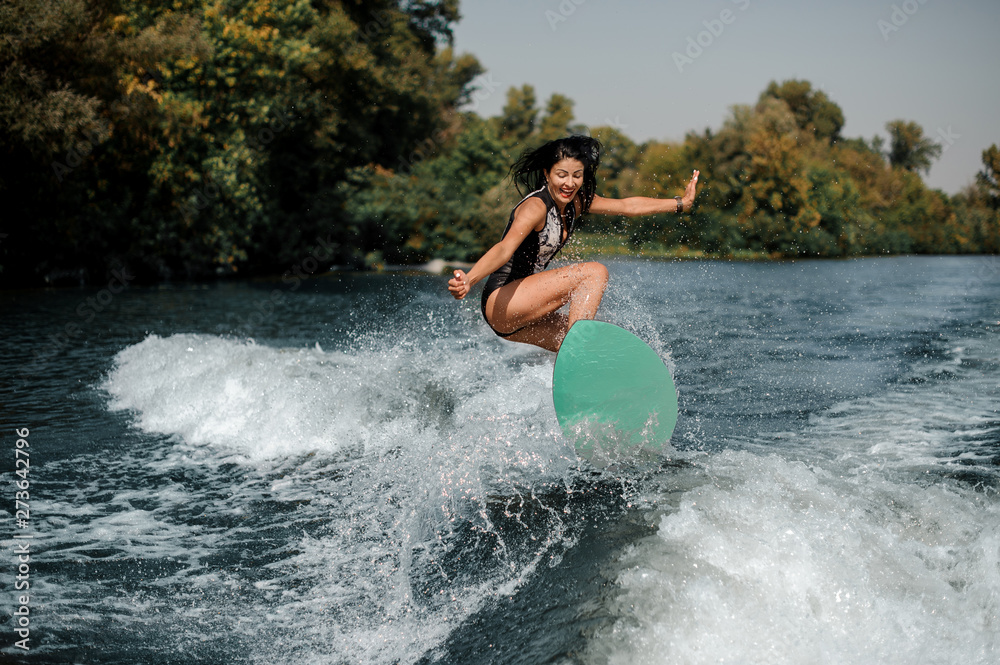 Happy surfgirl on a surfboard near seashore