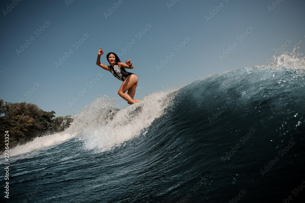 Brunette woman surfing on surfboard in sea