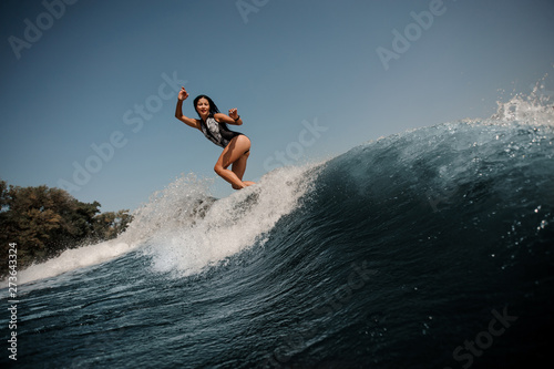 Brunette woman surfing on surfboard in sea