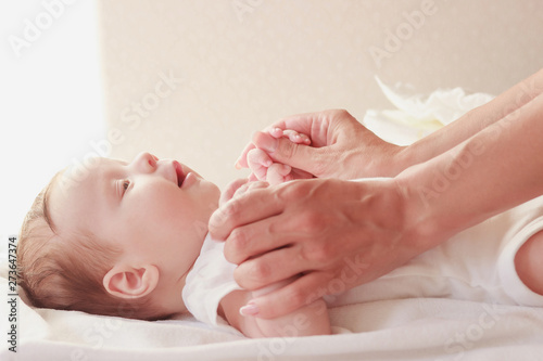 Baby and hands of mother, indoors, blurred background
