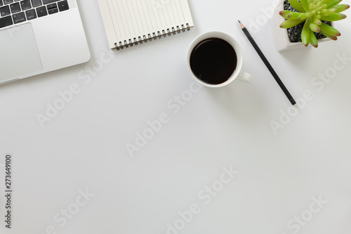 Flay lay, Top view office table desk with computer laptop, coffee, pencil, leaves with copy space white background.