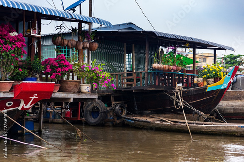 House boats with paper flowers  orchids and yellow flowers for Tet New Year Celebration  Mekong Delta  Vietnam.