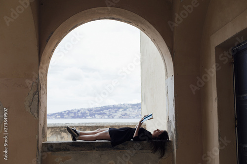 Girl reading a book on a horizontal posture