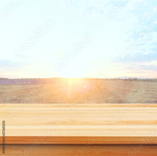 Wood table top on blur field background. Summer, nature concepts. For montage product display or design key visual layout.