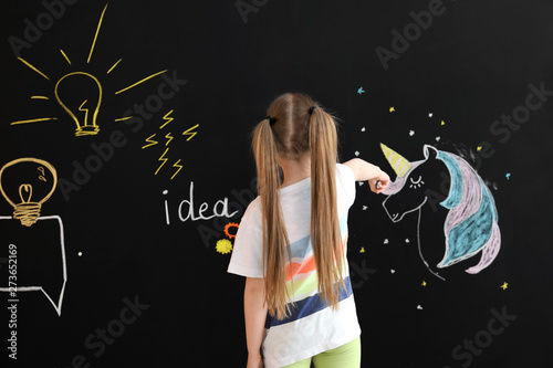 Cute little girl drawing on...