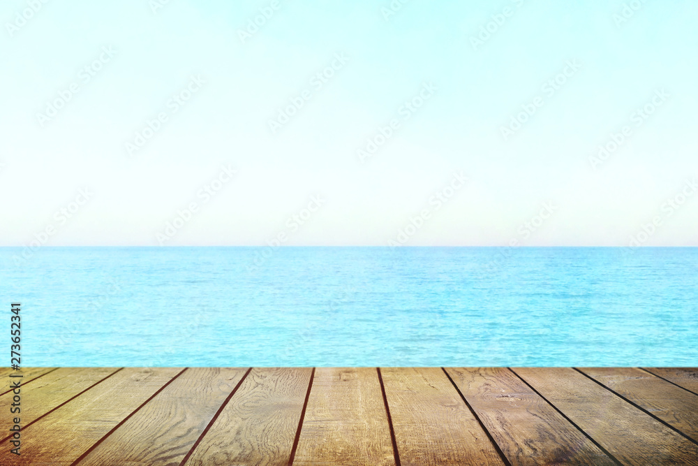 Table top with beach background, sky and cloud in sunny day for product display job showing. Wooden table for display or montage your products.