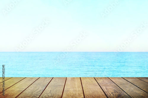 Table top with beach background, sky and cloud in sunny day for product display job showing. Wooden table for display or montage your products.