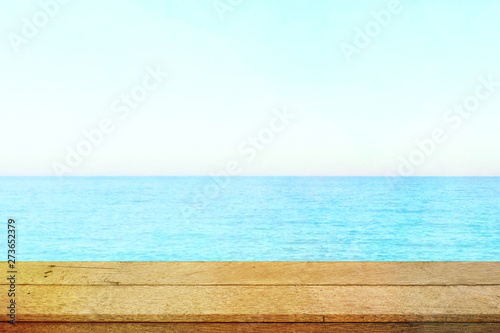 Table top with beach background, sky and cloud in sunny day for product display job showing. Wooden table for display or montage your products.