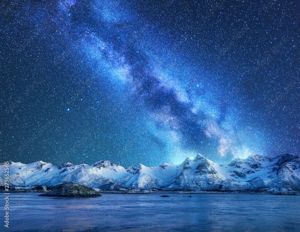 Bright Milky Way over snow covered mountains and sea at night in winter in Norway. Landscape with snowy rocks, starry sky, reflection in water, fjord. Lofoten Islands. Space. Beautiful milky way - obrazy, fototapety, plakaty 