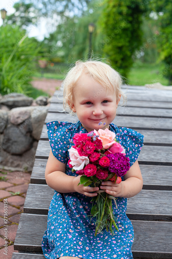 cute blonde girl is holding a bouquet of flowers cute blonde girl is holding a bouquet of flowers