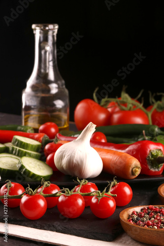 Healthy food. Vegetables on a black plate and stone cutting board and wooden background.