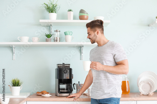 Handsome man using coffee m...