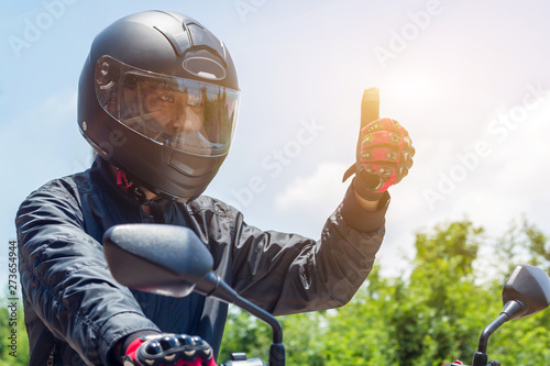 Man in a Motorcycle with helmet and gloves is an important protective clothing for motorcycling throttle control with sun light,safety concept