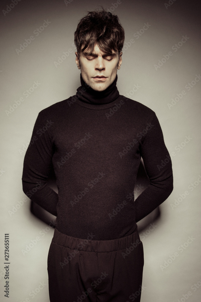 Fototapeta premium Strong stripped muscle male model in casual black look on white isolated font background