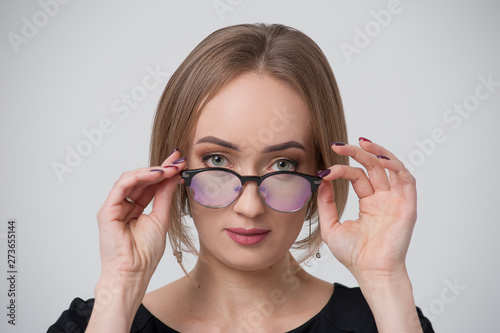 Portrait of charming young woman in stylish spectacles