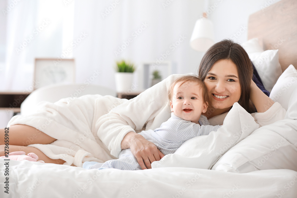 Happy mother with adorable baby boy on bed at home Happy mother with adorable baby boy on bed at home