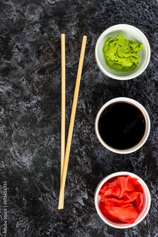 Set for sushi soy sauce ginger wasabi with chopstick on stone background Set for sushi soy sauce ginger wasabi with chopstick on stone background