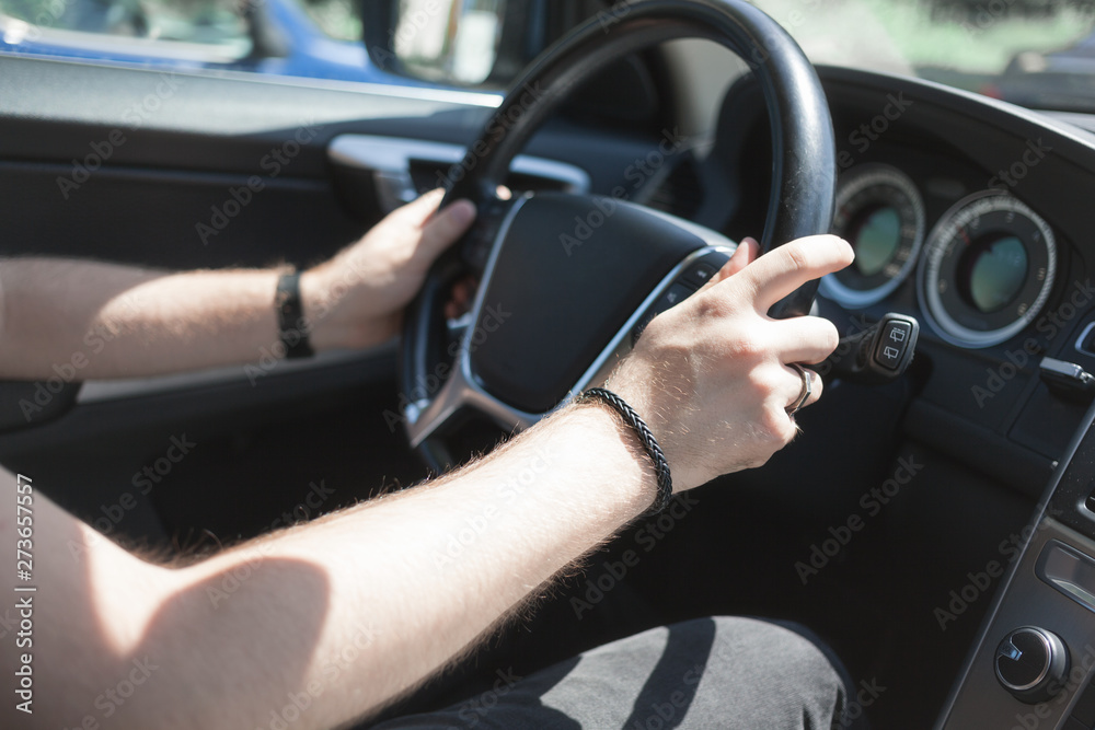 Man driving car, hands holding steering wheel