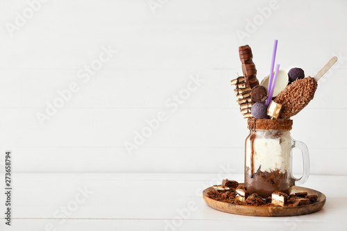 Mason jar with delicious freak shake on white table photo